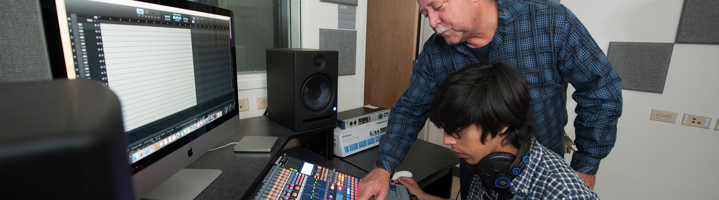 Professor guiding student on equipment use