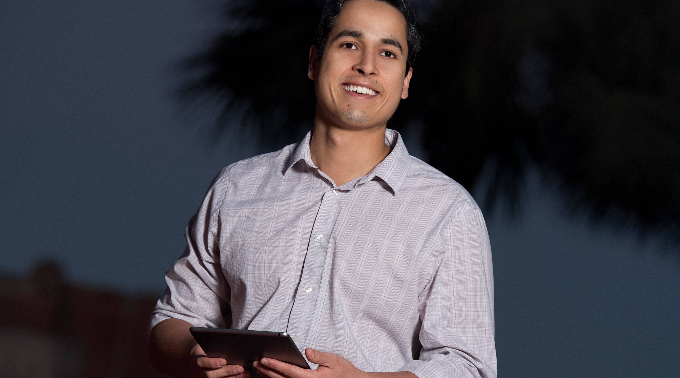 Graduate student in Palm Court holding iPad