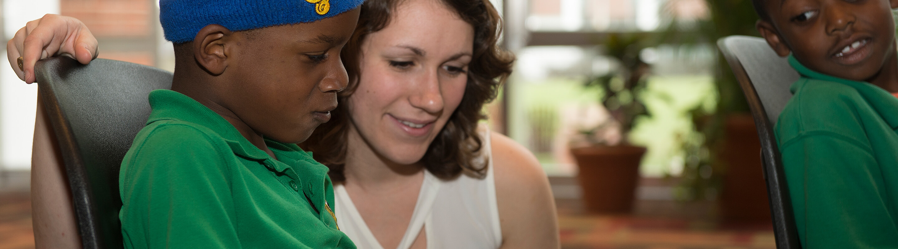 Student reading a book with a child