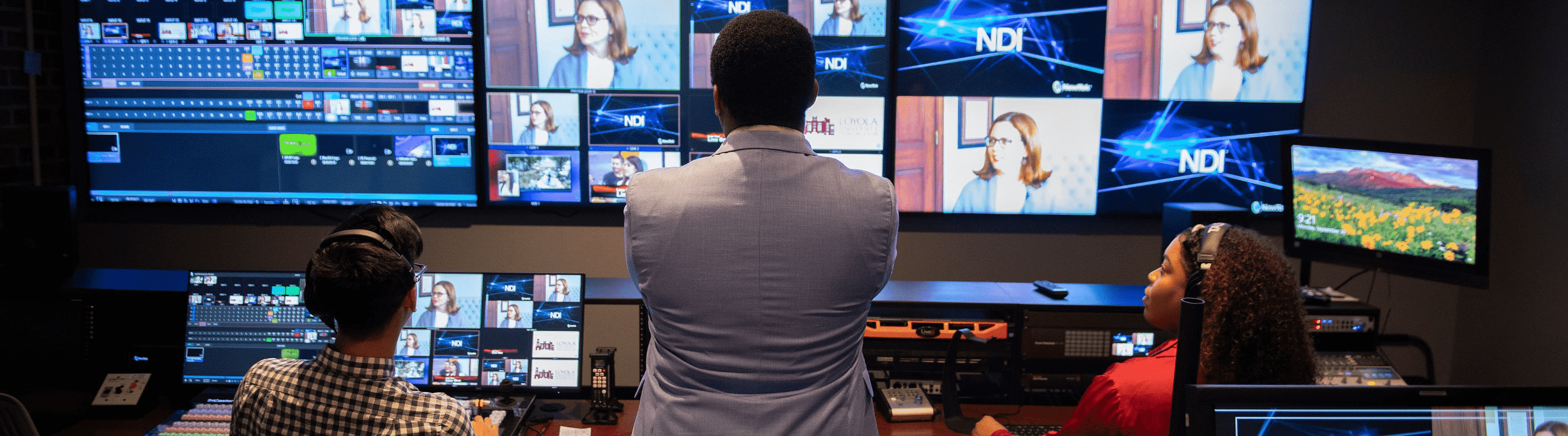 Online mass communications student standing in a control room.