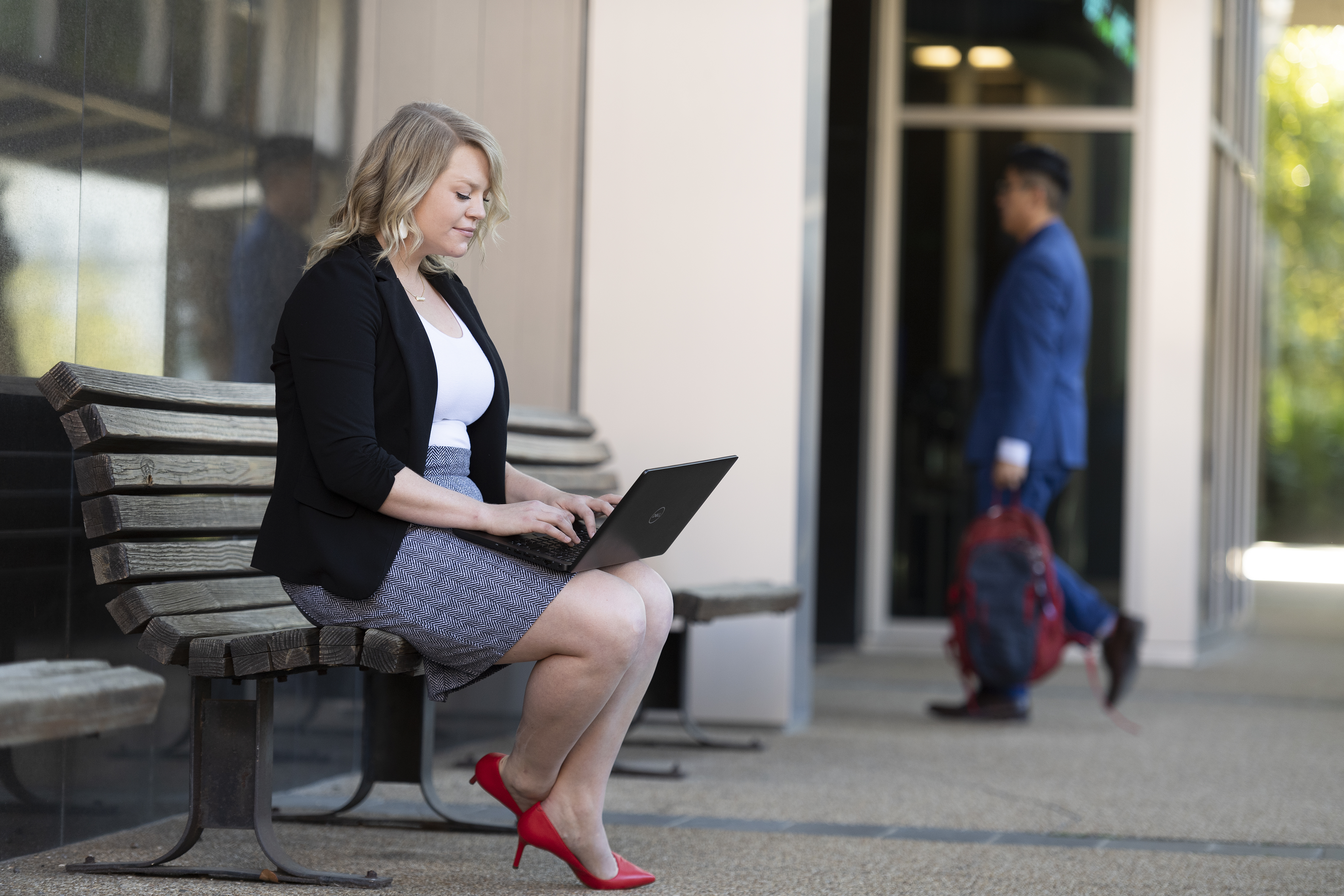 The sideview of a Loyola Online student working on their laptop