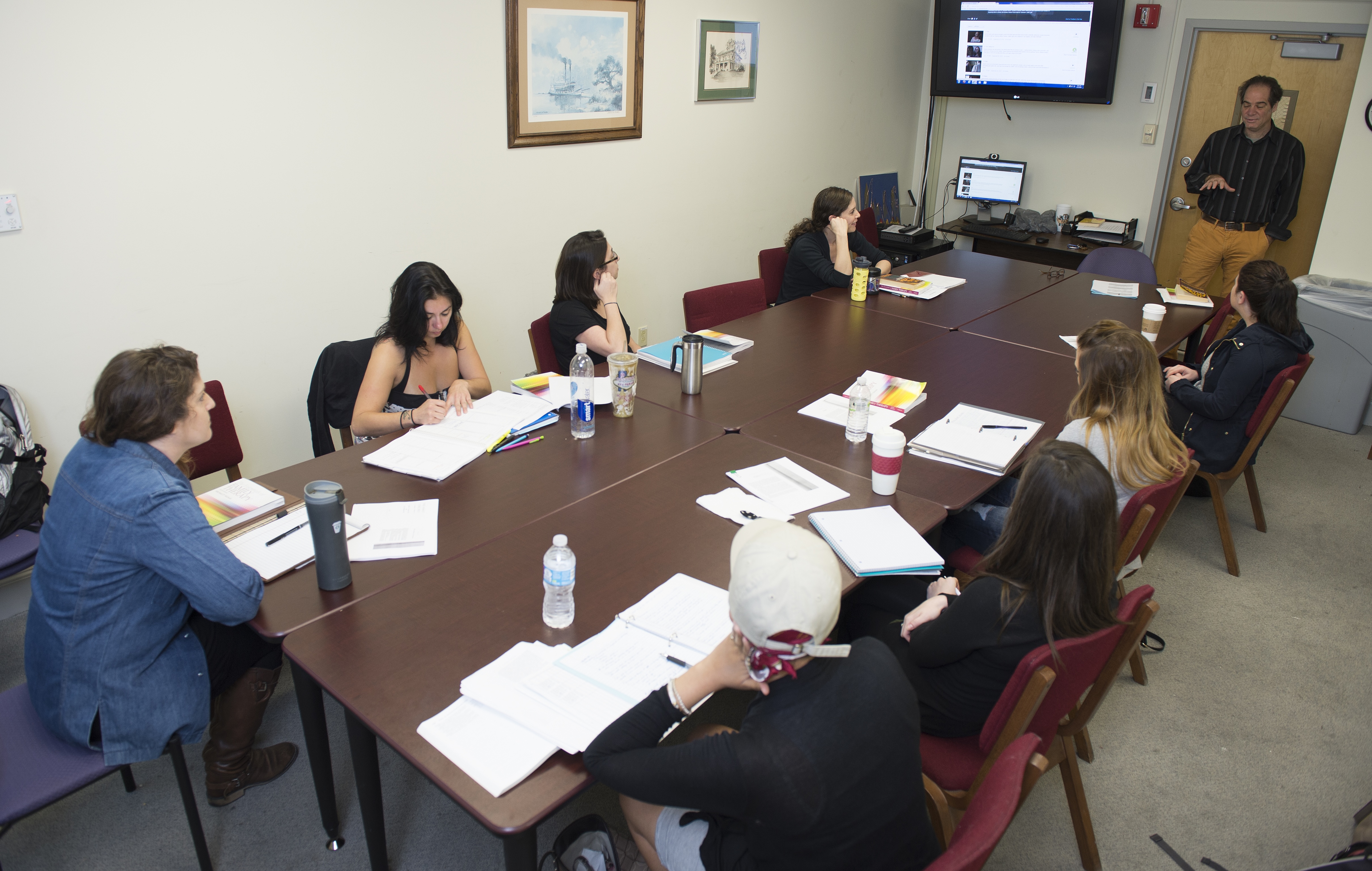 A group of Loyola Online students paying attention in classreviewing an assignment